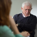 Psychologist listening about problems of senior man