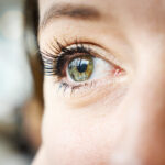 close up to a young woman's bright and green eyes. she is in love and dreams of her new boyfriend